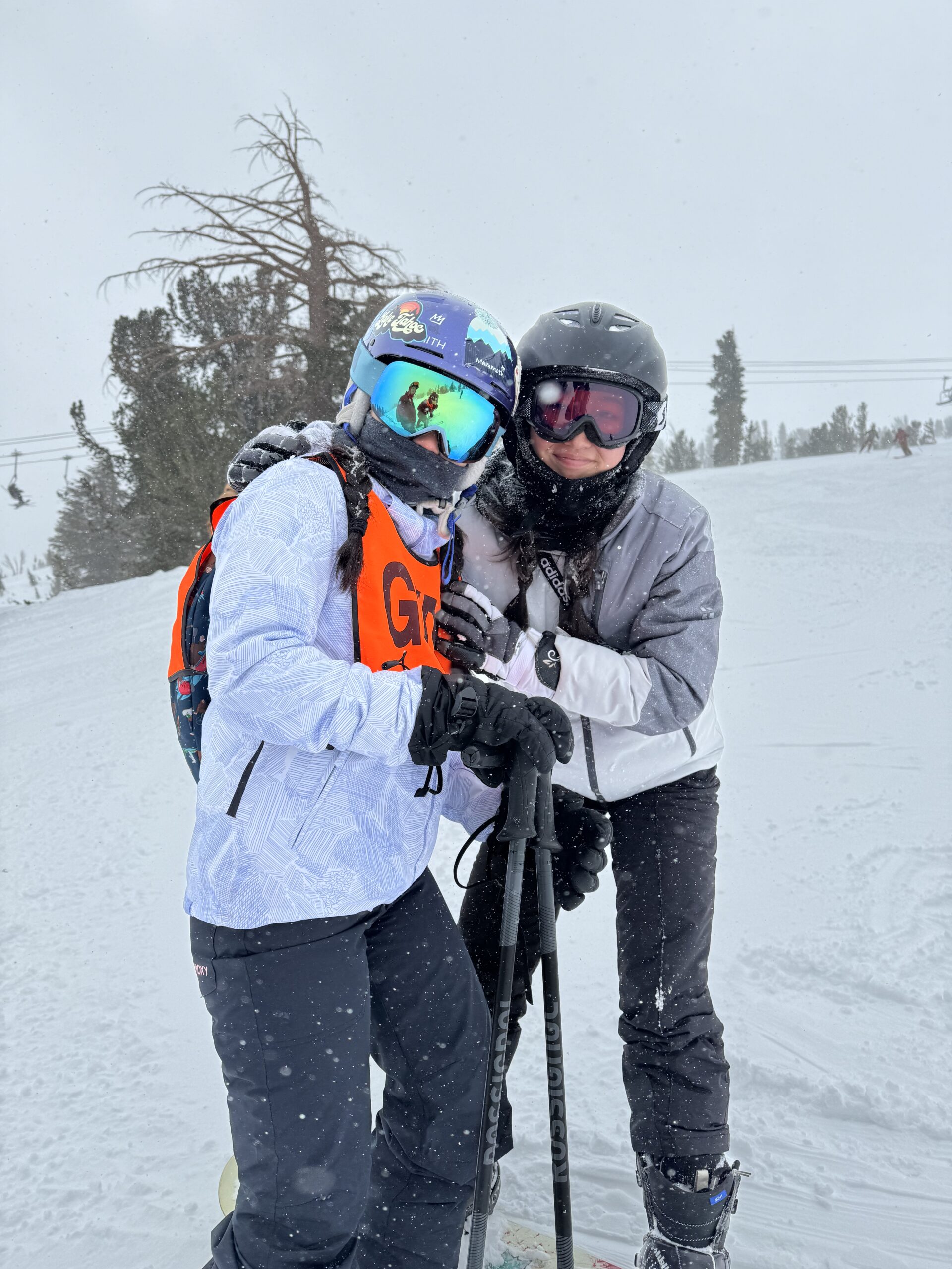2 female skier hugging each other.